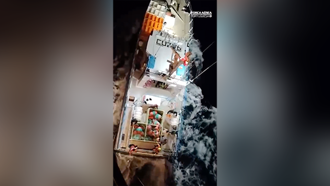 This image shows crews working to rescue a family that was forced to abandon their sailboat when a group of orcas destroyed it, forcing them to abandon ship before being helped by a passing fishing boat.