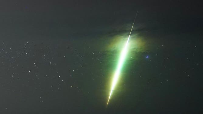 A fisherman watches a meteor during the Draconid meteor shower over Howick rocks in Northumberland.