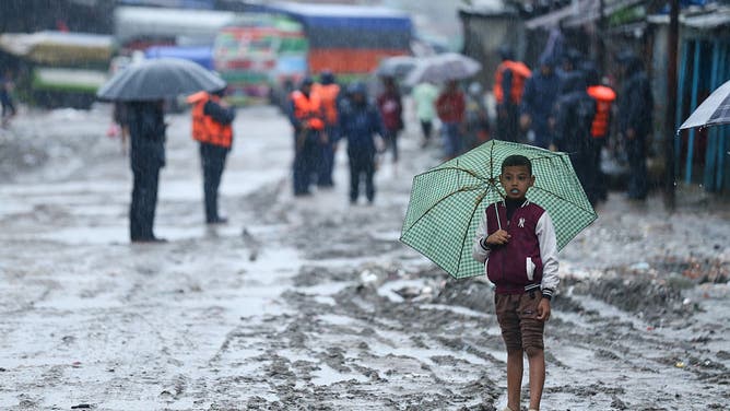 A displaced Nepali child wears an umbrella as he prepares to be evacuated from the flooded residential area along the riverbanks flowing through the Kathmandu Valley in Nepal on October 4, 2025, moving to higher ground following the heavy downpour due to the continued influence of moisture-laden monsoon winds from the Bay of Bengal, which triggers inundation in parts of the nation. In Nepal, the monsoon is particularly influenced by the Bay of Bengal, making it a major driver of monsoon-related disasters.