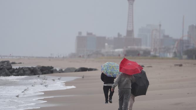 NEW YORK, UNITED STATES - OCTOBER 12: People spend time on Brighton Beach during the powerful nor'easter in Brooklyn, New York, United States on October 12, 2025. New York Governor Kathy Hochul declared a State of Emergency for eight counties of the state and canceled the Columbus Day Parade in New York City after urging New Yorkers to continue to prepare as a strong coastal storm is set to impact much of New York beginning Sunday afternoon. as a strong coastal storm is set to impact much of New York beginning Sunday afternoon. (Photo by Selcuk Acar/Anadolu via Getty Images)