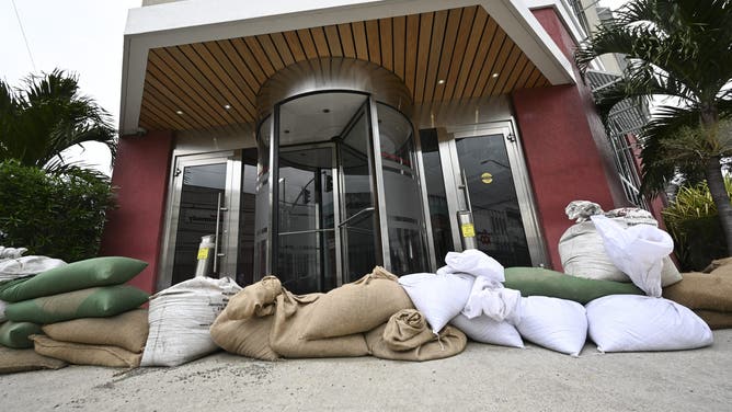 Sandbags are placed at the entrance of the Grace Kennedy building in preparation for the arrival of Hurricane Melissa in downtown Kingston, Jamaica, on October 25, 2025. Deadly storm Melissa strengthened Saturday afternoon into a Category 1 hurricane, with rapid intensification expected over the weekend as it cut a worryingly slow course toward the Caribbean island of Jamaica, forecasters said. (Photo by Ricardo Makyn / AFP) (Photo by RICARDO MAKYN/AFP via Getty Images)