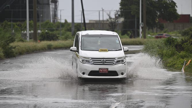 A motorist drives along flooded Michael Manley Boulevard in Kingston, Jamaica, as Jamaica starts to feel the effects of Hurricane Mellisa on October 26, 2025. Hurricane Melissa, already a major category 4 storm, gathered steam Sunday as it took aim at Jamaica and other parts of the Caribbean, with forecasters predicting catastrophic flooding and urging residents to seek shelter immediately. (Photo by Ricardo Makyn / AFP) (Photo by RICARDO MAKYN/AFP via Getty Images)