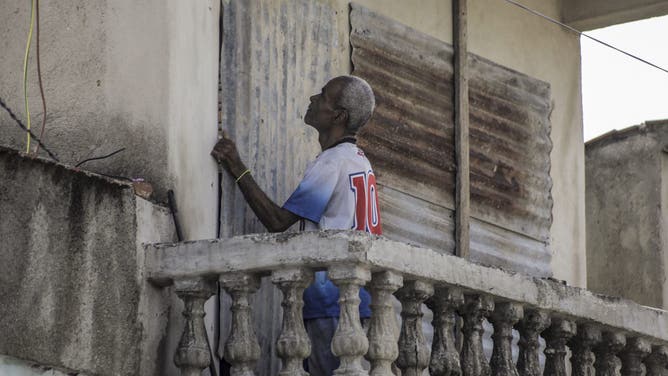 A man covers the windows of his home with corrugated iron ahead of the arrival of Hurricane Melissa in Santiago de Cuba, Cuba, on October 27, 2025. Hurricane Melissa strengthened Monday as it took aim at Jamaica and other parts of the Caribbean as a top-level Category 5 storm, with forecasters predicting catastrophic flooding and urging residents to seek shelter immediately. After passing over Jamaica, the storm was forecast to head north and cross over eastern Cuba on Tuesday night, while continuing to bring rain and heavy winds to Haiti and the Dominican Republic. (Photo by AFP) (Photo by STRINGER/AFP via Getty Images)
