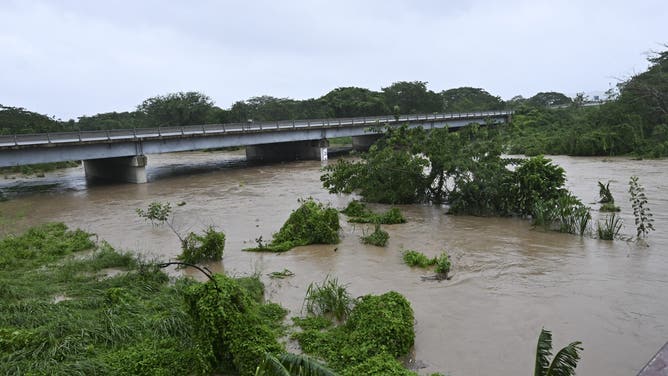 The Rio Cobre comes out of its banks near St. Catherine, Jamaica, shortly before Hurricane Melissa made landfall on October 28, 2025. Ferocious winds and torrential rain tore into Jamaica Tuesday as Hurricane Melissa made landfall, the worst storm ever to strike the island nation and one of the most powerful hurricanes on record. The extremely violent Category 5 system was still crawling across the Caribbean, promising catastrophic floods and life-threatening conditions as maximum sustained winds reached a staggering 185 miles per hour (295 kilometers per hour). (Photo by Ricardo Makyn / AFP) (Photo by RICARDO MAKYN/AFP via Getty Images)