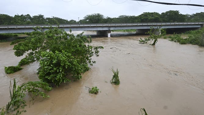 The Rio Cobre comes out of its banks near St. Catherine, Jamaica, shortly before Hurricane Melissa made landfall on October 28, 2025. Ferocious winds and torrential rain tore into Jamaica Tuesday as Hurricane Melissa made landfall, the worst storm ever to strike the island nation and one of the most powerful hurricanes on record. The extremely violent Category 5 system was still crawling across the Caribbean, promising catastrophic floods and life-threatening conditions as maximum sustained winds reached a staggering 185 miles per hour (295 kilometers per hour). (Photo by Ricardo Makyn / AFP) (Photo by RICARDO MAKYN/AFP via Getty Images)