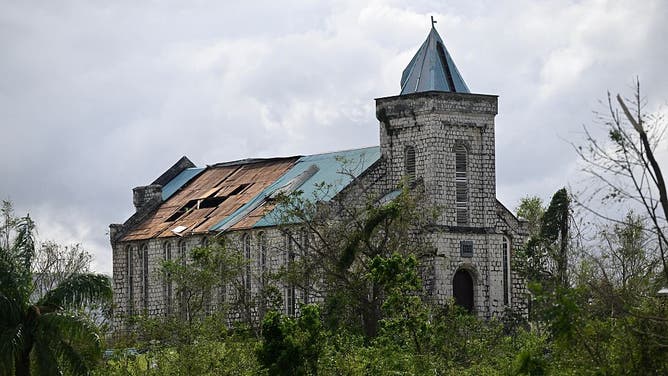A Church with sections of its roof damage is seen damage following the passage of Hurricane Melissa, outside Santa Cruz, St Elizabeth, Jamaica on October 29, 2025. Hurricane Melissa ripped up trees and knocked out power after making landfall in Jamaica on October 28, 2025 as one of the most powerful hurricanes on record, inundating the island nation with rains that threaten flash floods and landslides.
