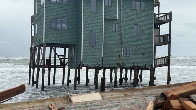 A green house remains standing after a home collapsed into it on Thursday in Buxton.
