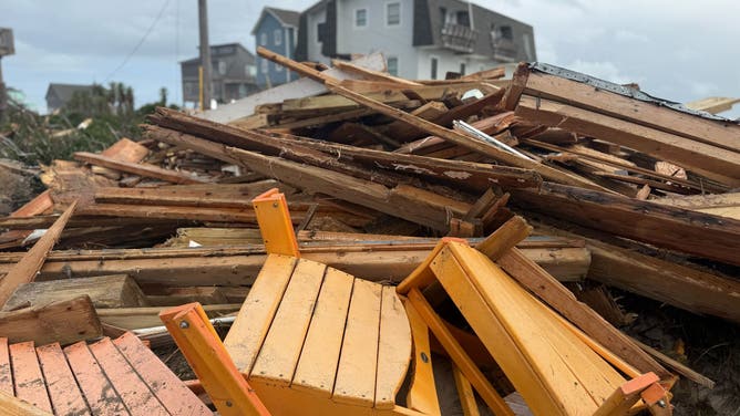 Debris from collapsed homes sits in a massive pile on the beach in Buxton.