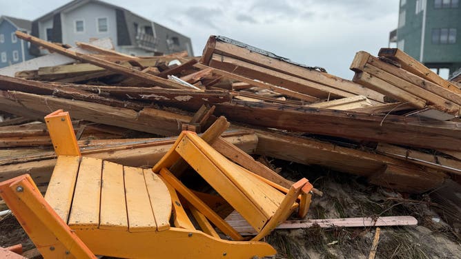 Debris from collapsed homes sits in a massive pile on the beach in Buxton.