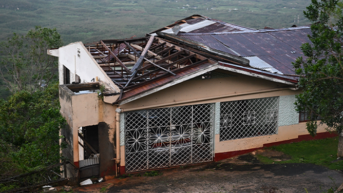 A house with a damaged roof is seen after the passage of Hurricane Melissa in Manchester, Jamaica, on October 28, 2025. Hurricane Melissa ripped up trees and knocked out power after making landfall in Jamaica on October 28, 2025 as one of the most powerful hurricanes on record, inundating the island nation with rains that threaten flash floods and landslides. (Photo by Ricardo Makyn / AFP) (Photo by RICARDO MAKYN/AFP via Getty Images)
