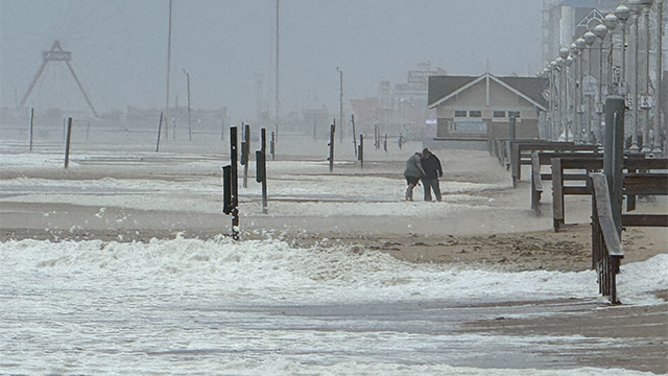 People are seen walking on the beach in Ocean City, Maryland, during a nor'easter on Oct. 12, 2025.