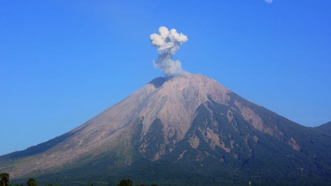 FILE - This photo taken on Oct. 1, 2023 shows volcanic materials spewing from Mount Semeru, as seen from Lumajang, East Java, Indonesia. 