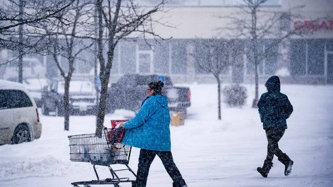 Shoppers exit a grocery store during a winter storm ahead of the Iowa caucus in Des Moines, Iowa, US, on Friday, Jan. 12, 2024.