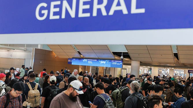 FILE - Travelers wait in line at a Transportation Security Administration (TSA) checkpoint at Dallas-Fort Worth International Airport (DFW) in Dallas, Texas, US, on Monday, Oct. 20, 2025. US air travel is starting to show signs of strain as lawmakers remain divided over a government shutdown that has stretched into its third week.