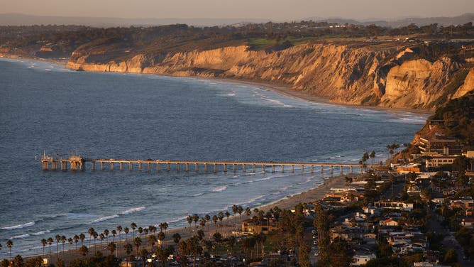 SAN DIEGO, CALIFORNIA - OCTOBER 15: UC San Diego's Ellen Browning Scripps Memorial Pier with the bluffs of Black's Beach along the La Jolla coastline is seen at sunset on a clear, fall day on October 15, 2025 in San Diego, California.