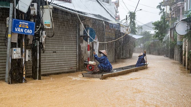 HUE, VIETNAM - NOVEMBER 3: People row a boat through a flooded street as heavy rain continues on November 3, 2025 in Hue, Vietnam. Central Vietnam has been hit by heavy rain that triggered flooding since October 26, killing at least 35 people. 