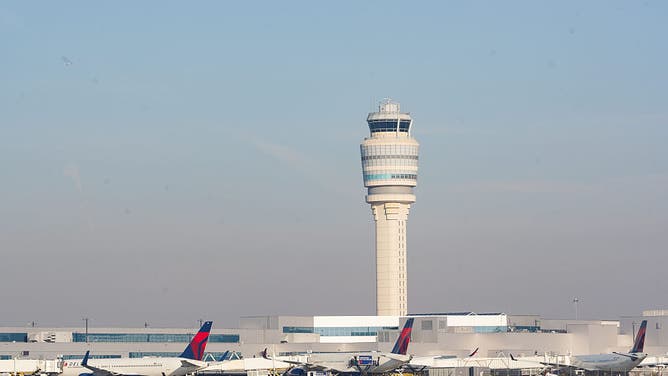FILE - ATLANTA, GEORGIA - NOVEMBER 7: Planes go past the air traffic control tower as people travel through Hartsfield-Jackson Atlanta International Airport on November 7, 2025 in Atlanta, Georgia.