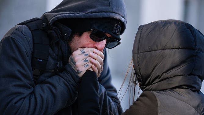UNITED STATES - NOVEMBER 11: Visitors to the the National World War II Memorial try to stay warm on Veterans Day on Tuesday, November 11, 2025.