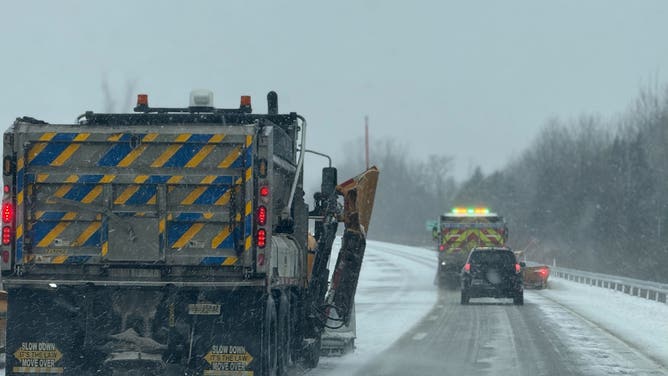 Snow plows clear lake-effect snow along Interstate 86 in Sherman, New York on Thanksgiving Day.