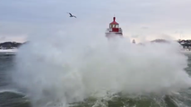 Drone video captures massive waves violently crashing along Lake Michigan coast, towering over lighthouse