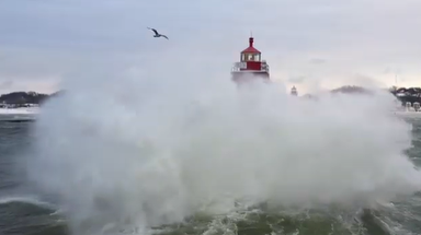 Drone video captures massive waves violently crashing along Lake Michigan coast, towering over lighthouse