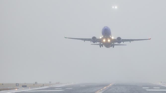 A Southwest plane takes off as snow begins to fall at Ronald Reagan National Airport (DCA) in Arlington, Virginia, U.S., on Sunday, Jan. 16, 2022.