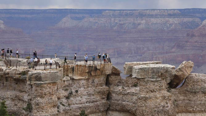 GRAND CANYON NATIONAL PARK, ARIZONA - SEPTEMBER 8, 2022: Visitors take photos and gather at Mather Point Lookout, on the South Rim of Grand Canyon National Park, on Thursday evening, September 8, 2022.