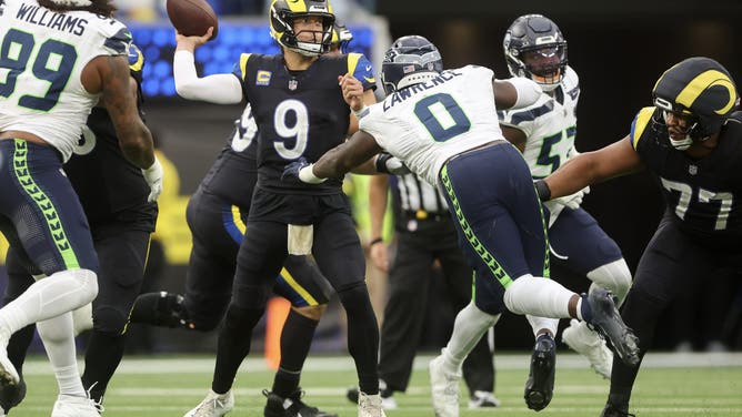 INGLEWOOD, CALIFORNIA - NOVEMBER 16: Matthew Stafford #9 of the Los Angeles Rams passes the ball under pressure from DeMarcus Lawrence #0 of the Seattle Seahawks during the third quarter at SoFi Stadium on November 16, 2025 in Inglewood, California.