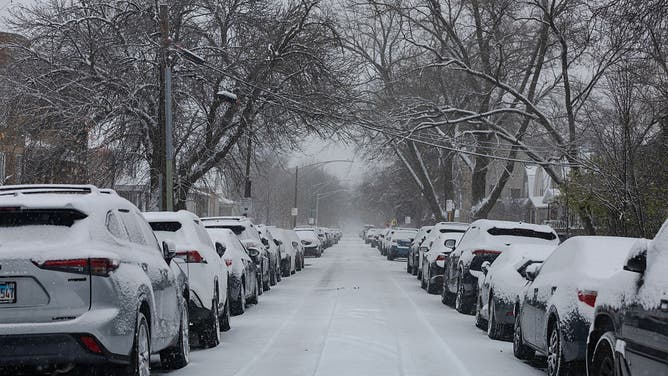 Snow covered vehicles parked on a street during a snowstorm in Chicago, Illinois, US, on Saturday, Nov. 29, 2025. Hundreds of flights have been canceled in and around Chicago and roads are becoming treacherous as one of the busiest travel weekends of the year collides with a major storm bringing wintery conditions throughout the US Midwest Saturday. 