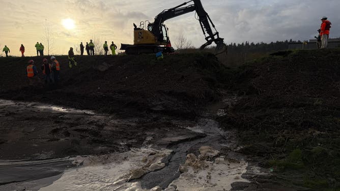 Crews work to repair a levee failure in Washington