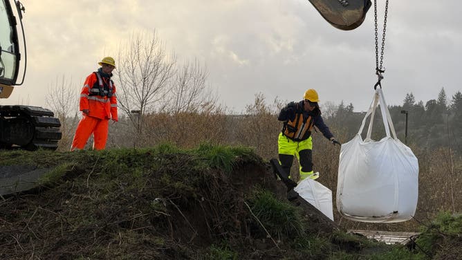 Crews work to repair a levee failure in Washington