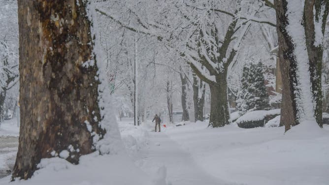 ROYAL OAK, MICHIGAN, USA - JANUARY 25, 2023: A contract worker clears snow for a local apartment complex as forecasts project the winter storm dropping up to 8 inches in Metro Detroit, in Royal Oak, Michigan, United States on January 25, 2023.