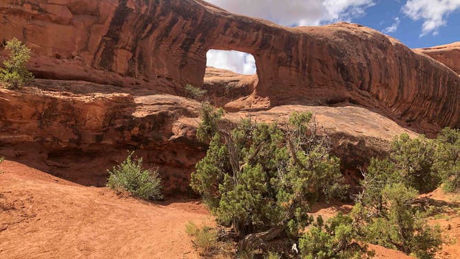 Picture Frame Arch with streaks of desert varnish in the Entrada Sandstone of Lone Rock Butte near Moab, Utah.