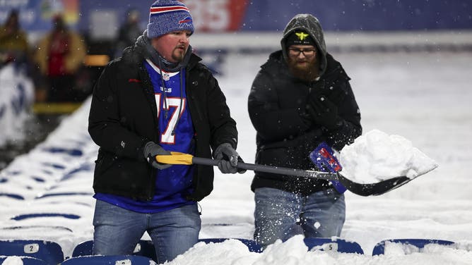 ORCHARD PARK, NEW YORK - DECEMBER 1: Buffalo Bills fans shovel snow from seats prior to an NFL football game between the Buffalo Bills and the San Francisco 49ers at Highmark Stadium on December 1, 2024 in Orchard Park, New York.