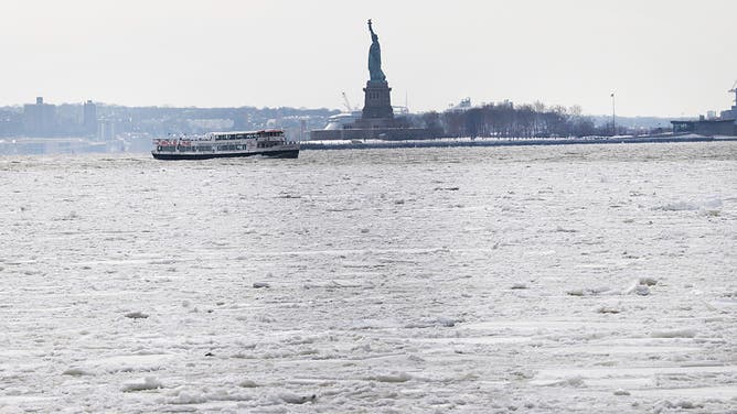 NEW YORK, NEW YORK -JANUARY 27: The Statue of Liberty stands in the distance as ice floats coveri part of the Hudson River along the Manhattan shoreline as New York City experiences frigid temperatures following a winter storm over the weekend on January 27, 2026, in New York City. 