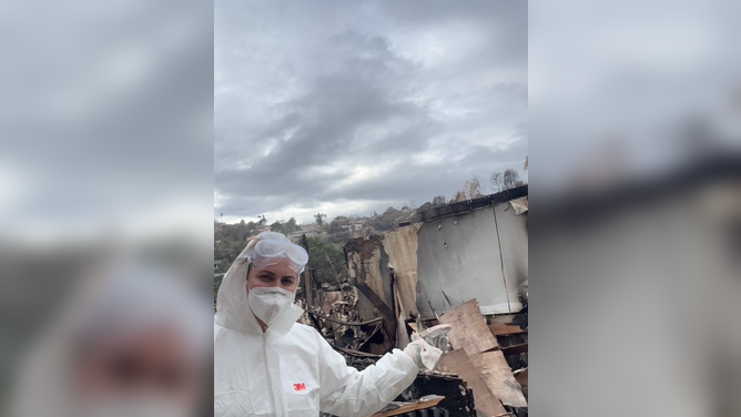 Laura Nativo poses in front of a heap of damage left behind from her apartment burning down amid the Palisades Wildfire.