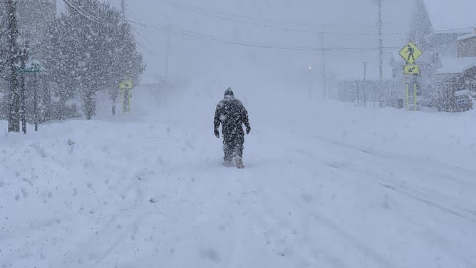 A person treks through feet of snow in Fair Haven, NY on Jan. 2, 2026.