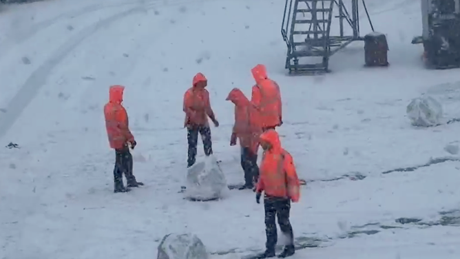 Workers at Amsterdam Airport Schiphol roll snowballs on Jan. 6, 2026. 