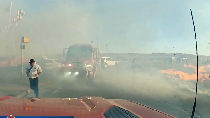 Smoke from a small wildfire crowds firefighters in Colorado.