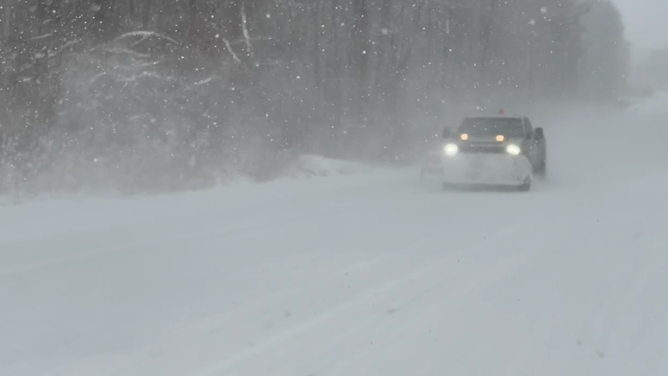 A snow plow drives through a lake-effect snow squall on Jan. 14 in Benton Harbor, Michigan.
