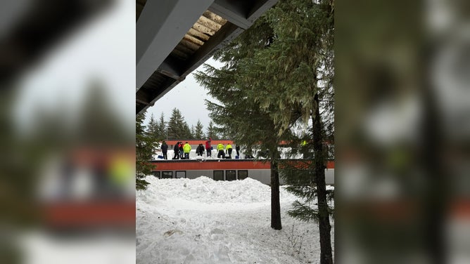 Crews remove snow from the lower roofs at Mendenhall River Community School.
