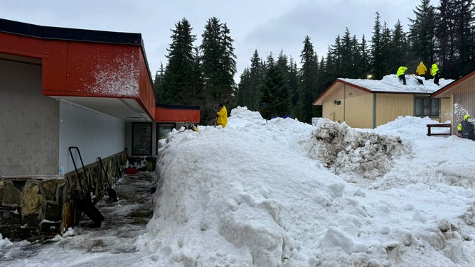Crews work to clear nearly two million pounds of snow off of Mendenhall River Community School.