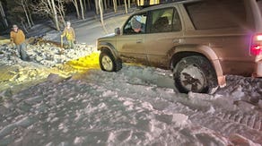 Photos: First responders use snowmobiles to rescue stranded drivers in heavy snow conditions