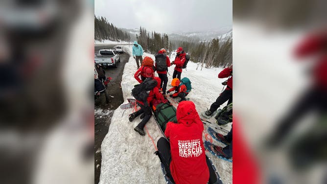 Search and Rescue officials extract a hiker wrapped in a blanket due to mild hypothermia conditions.