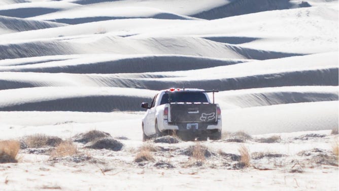 The vehicle that drove through Eureka Dunes is believed to be a white 2021 Toyota Tacoma with California plates, a bed equipment rack, and a black Fox Racing® tailgate cover. 