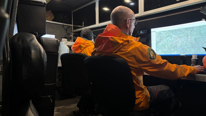 Nevada County Sheriff's office look at a map of the mountains amid search and rescue operations.