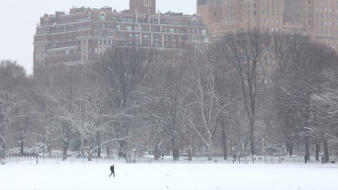A person walks through a snow-covered Central Park in New York City on December 27, 2025.