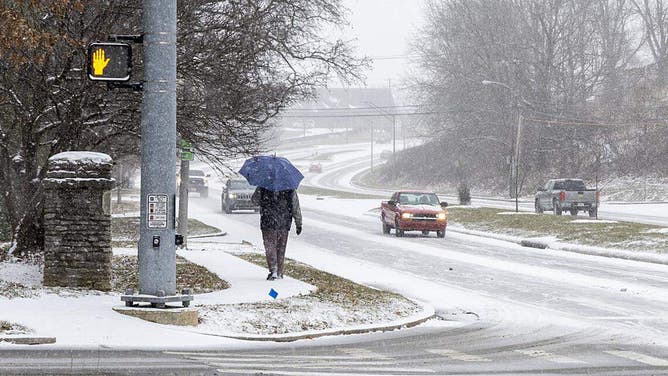 FILE - A pedestrian walks along Lexington's Tates Creek Road Jan. 24, 2026, as winter storm starts to bring heavy snowfall and sleet across Lexington and Central Kentucky.