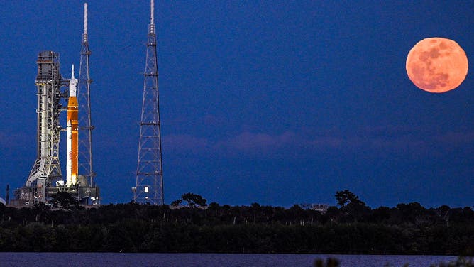 A full moon rises as the Space Launch System (SLS) rocket and the Orion spacecraft, integrated for the Artemis II mission, are seen at Launch Pad 39B at the Kennedy Space Center in Cape Canaveral, Florida, on February 1, 2026 ahead of the first crewed mission to the Moon in more than 50 years. 