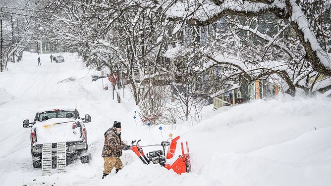 A man clears newly fallen snow with a snowblower on Winter Street in Montpelier, Vermont, after a major winter storm dumped more than a foot of snow on the capital of Vermont on Jan. 26, 2026. 